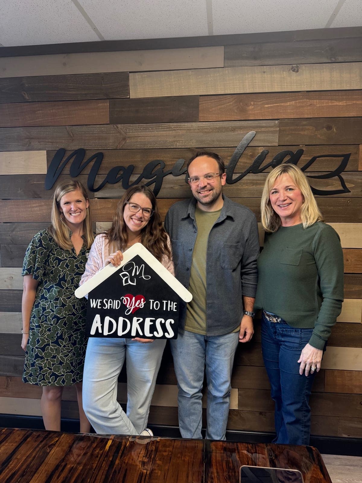 Johnson Family Homes buyers celebrating their new home with a 'We said yes to the address' sign