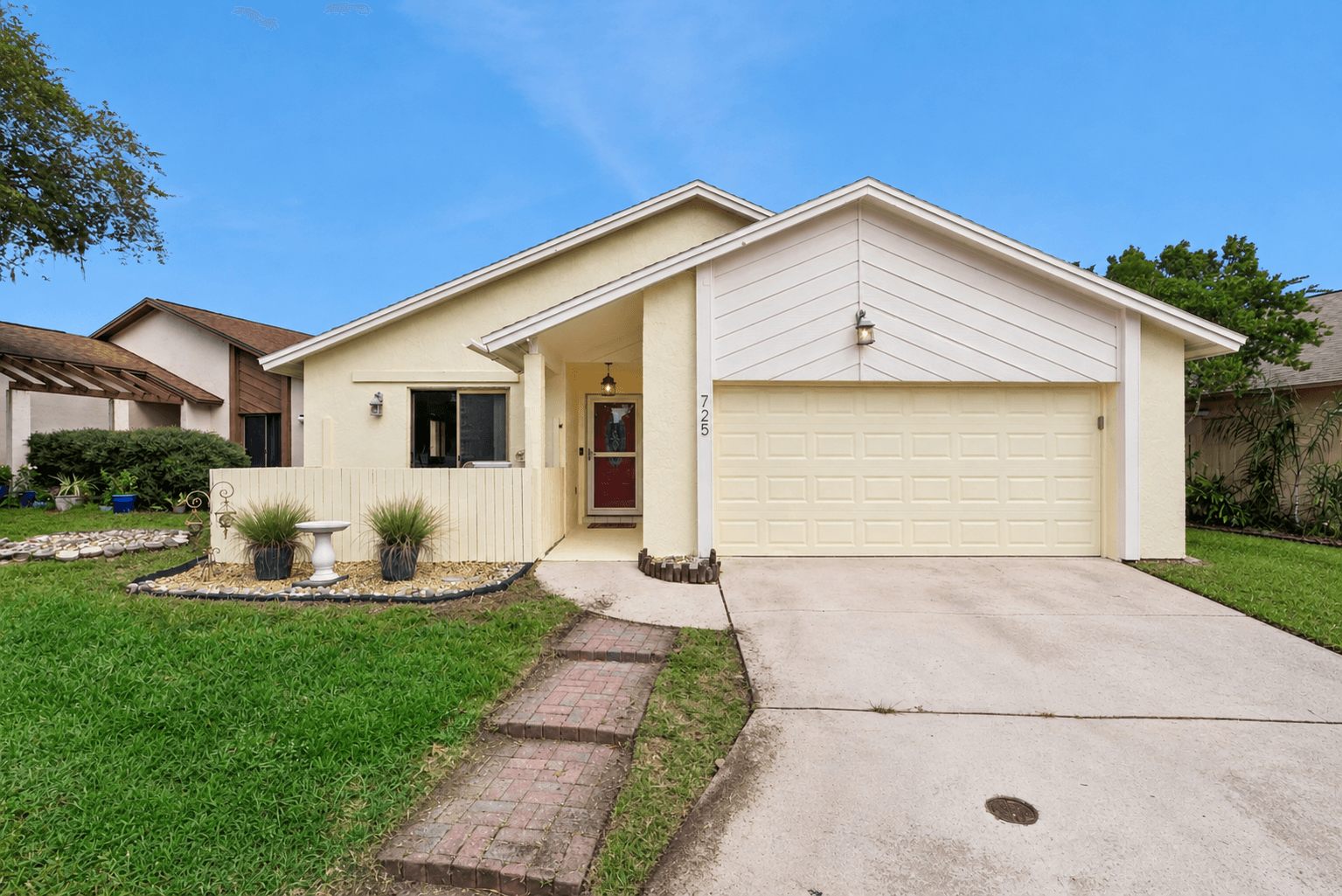 Front of 725 Adidas Rd, a single-story cream stucco home with a two-car garage